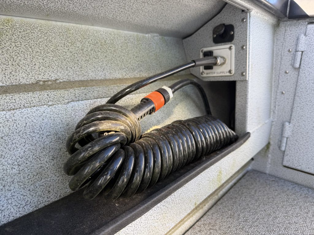 Washdown pump hose in storage compartment
